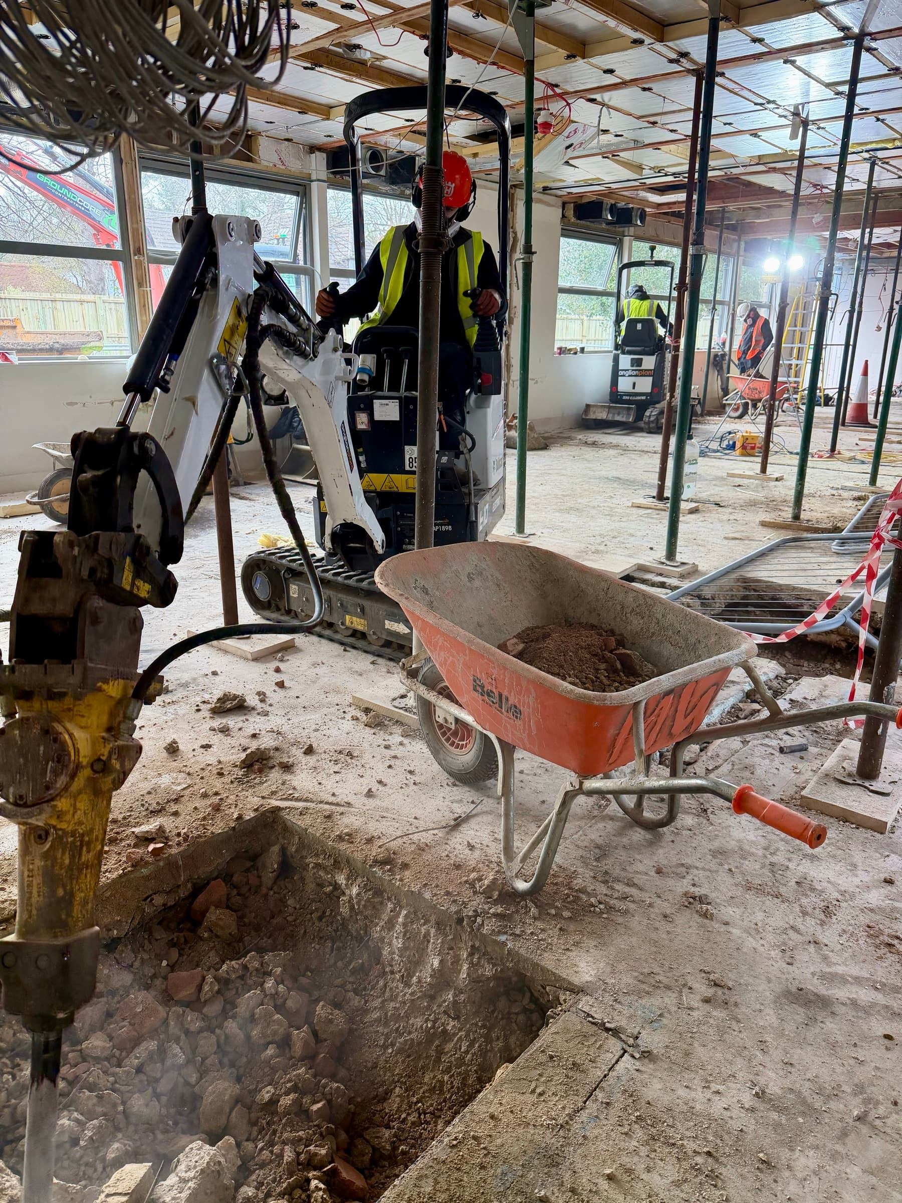 A mini excavator stripping out the inside of a building in Cambridge