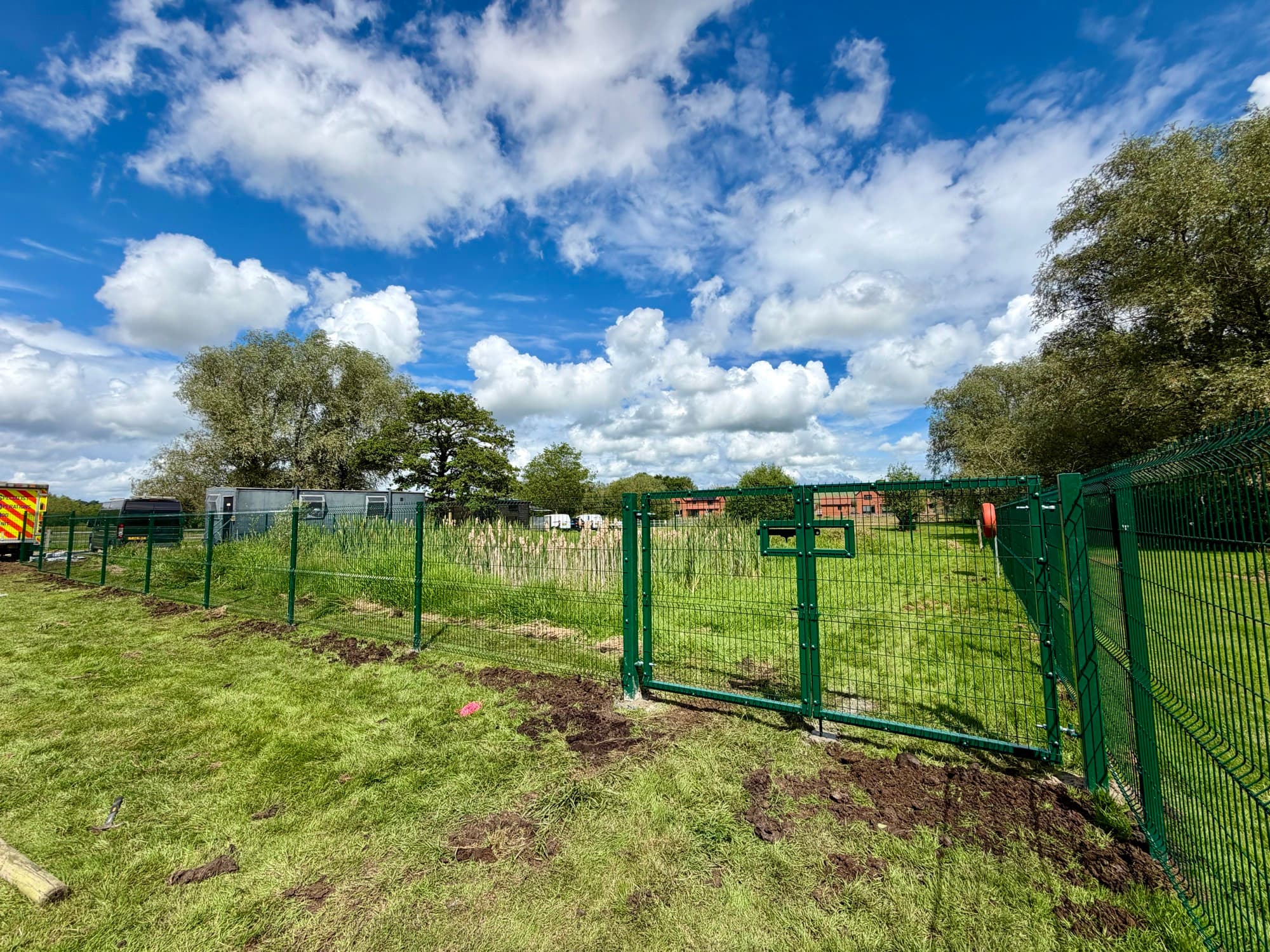 Mesh security fencing with a gate in a field