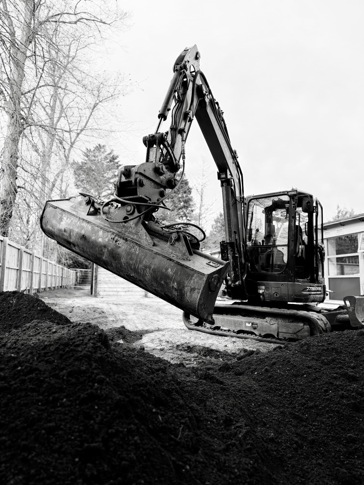Grading and levelling ground with an excavator