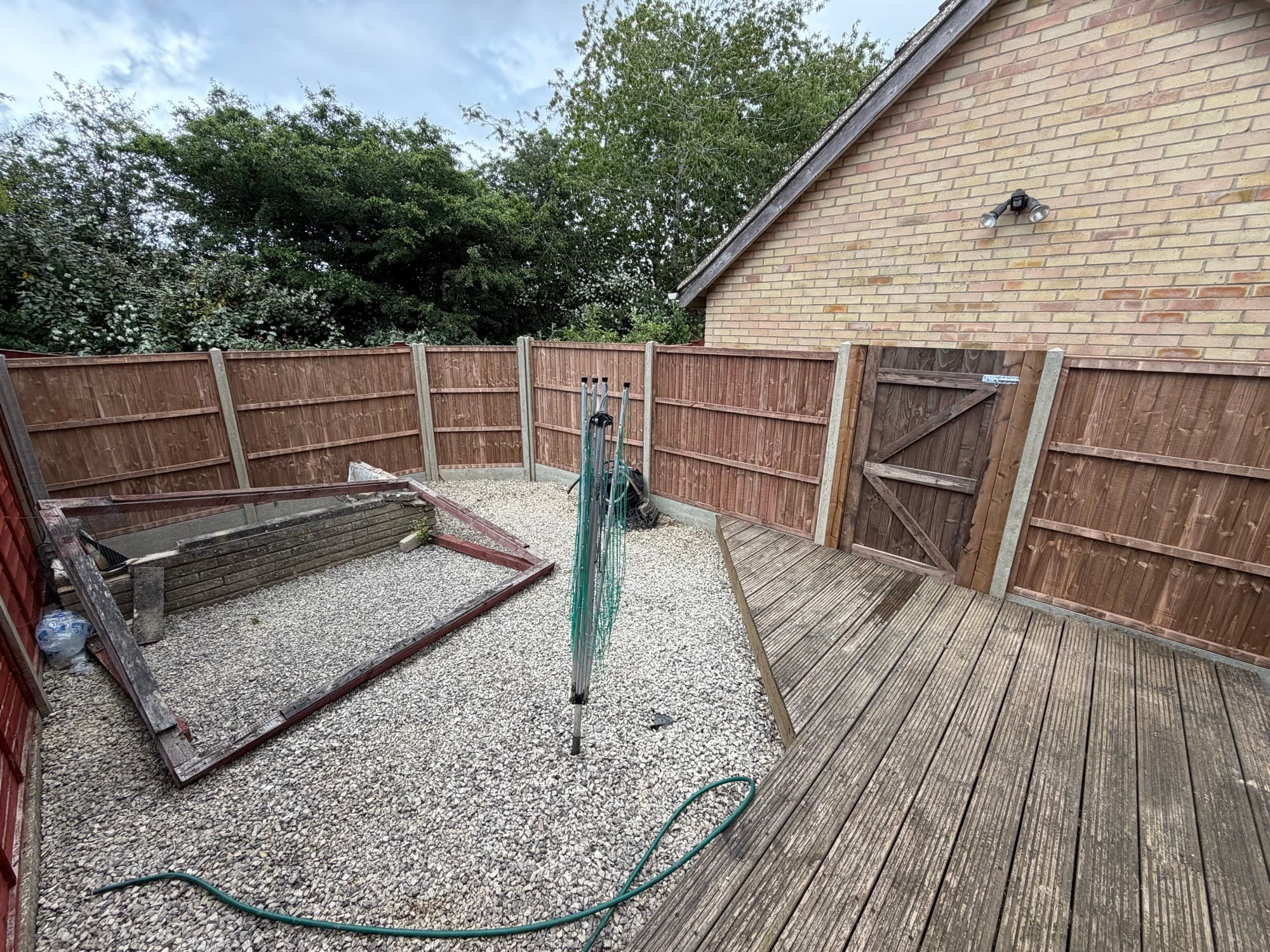A finished garden with decking, gravel and fencing
